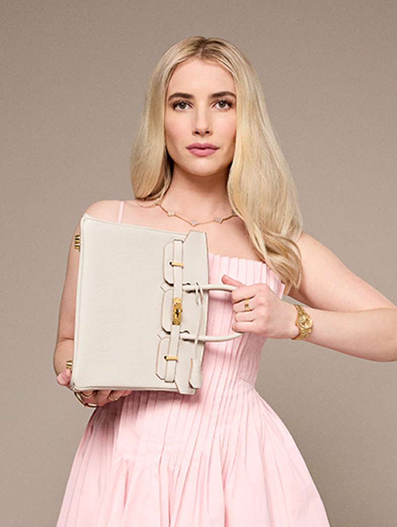 Emma Roberts wearing a light pink dress and holding a beige Hermes Birkin 25 sideways